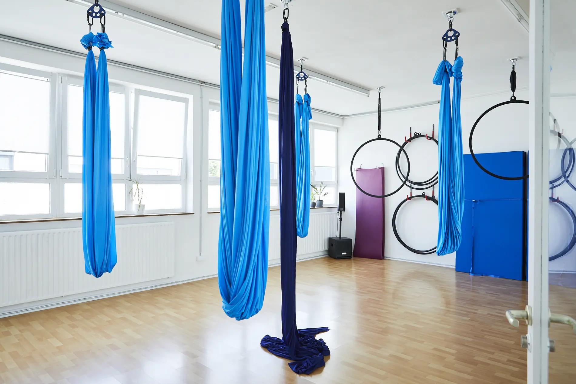 Blaue Aerial Silks und ein Hoop im Trainingsraum