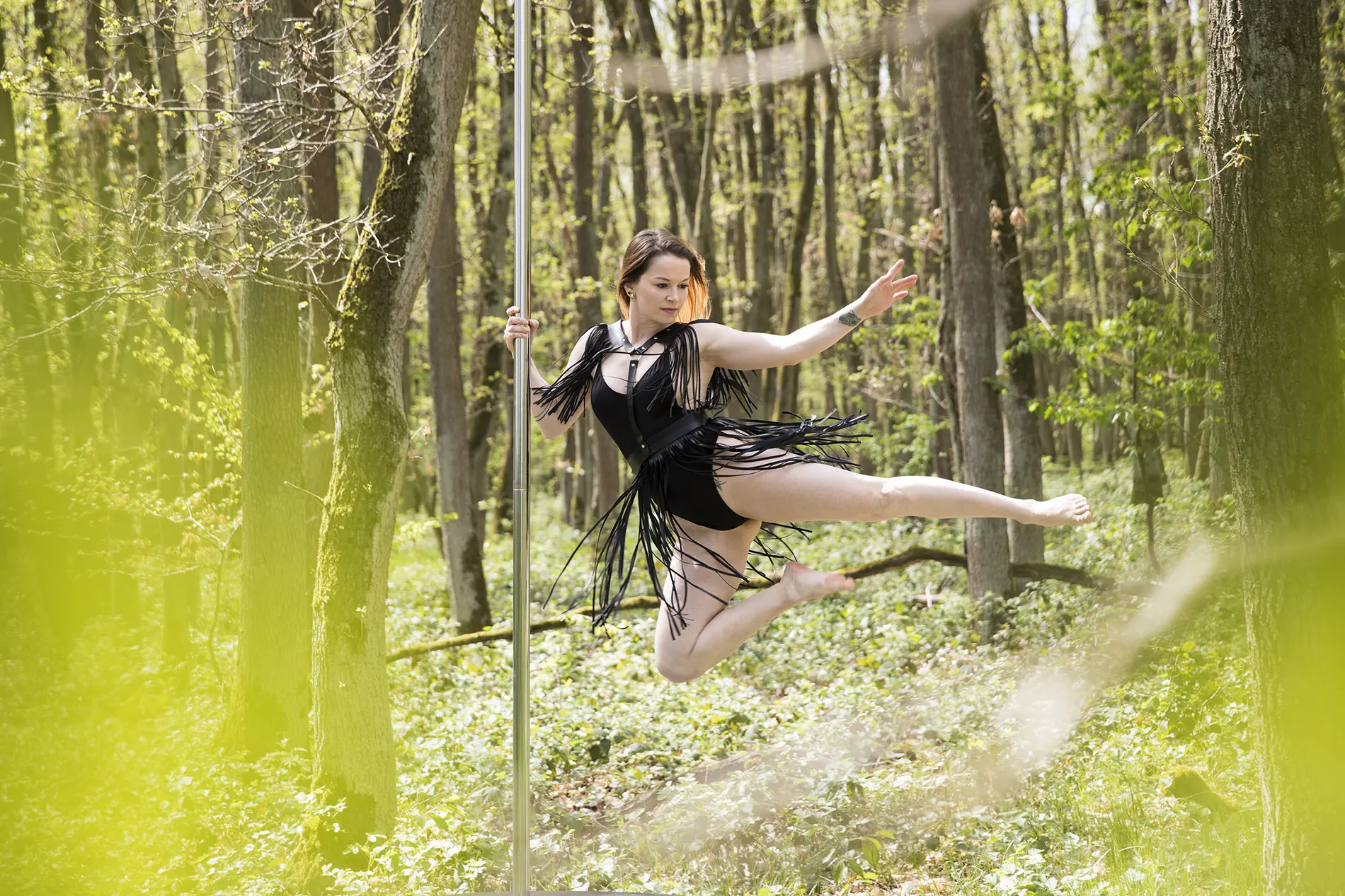 Tänzerin am Aerial Hoop, aufgehängt zwischen Bäumen im Wald