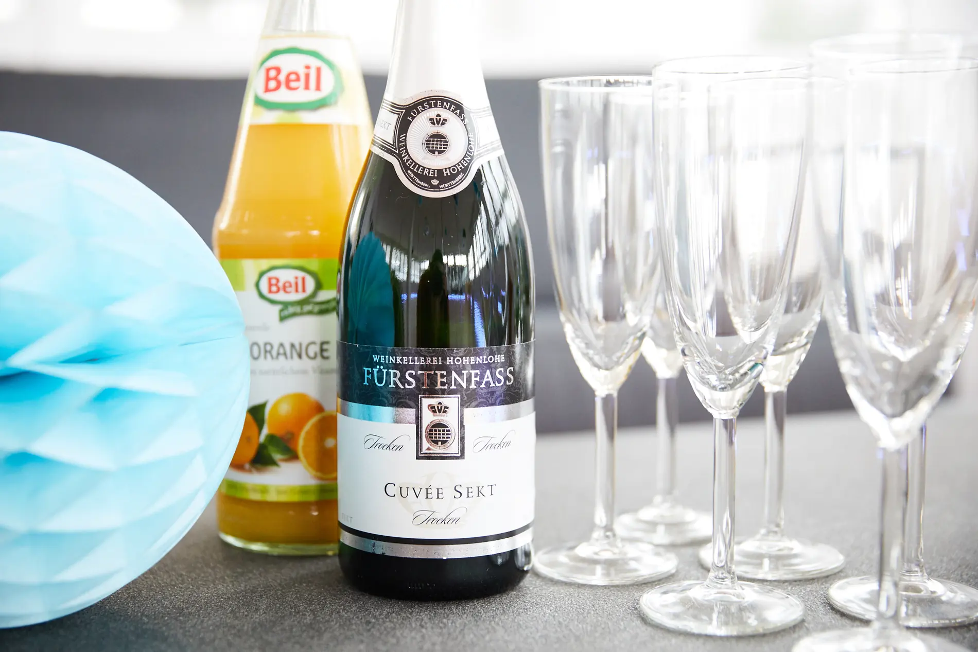 Sekt, Saft und blaue Dekoration auf einem Tisch im Studio