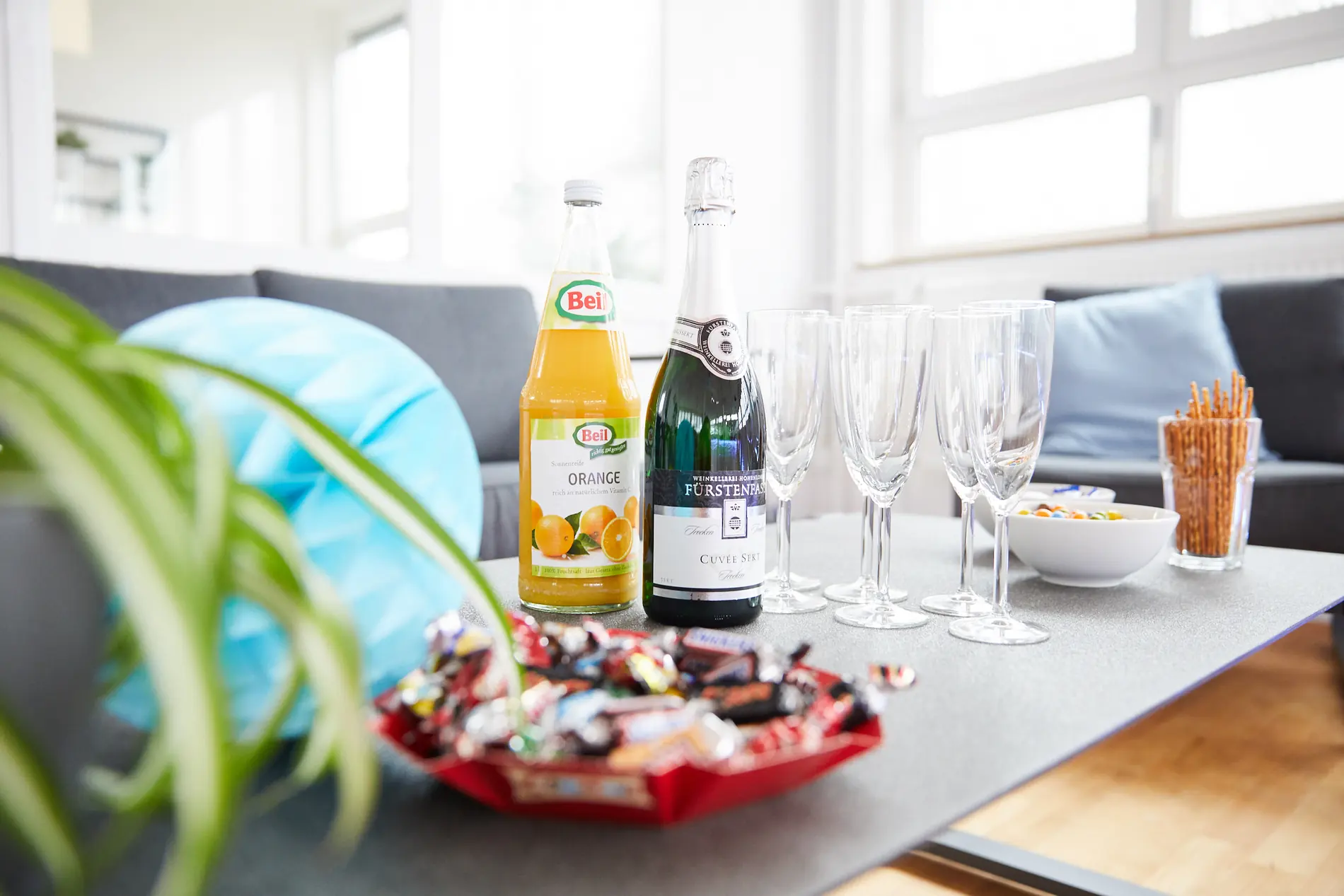 Sektflasche, Saft und Gläser auf einem Tisch im Studio
