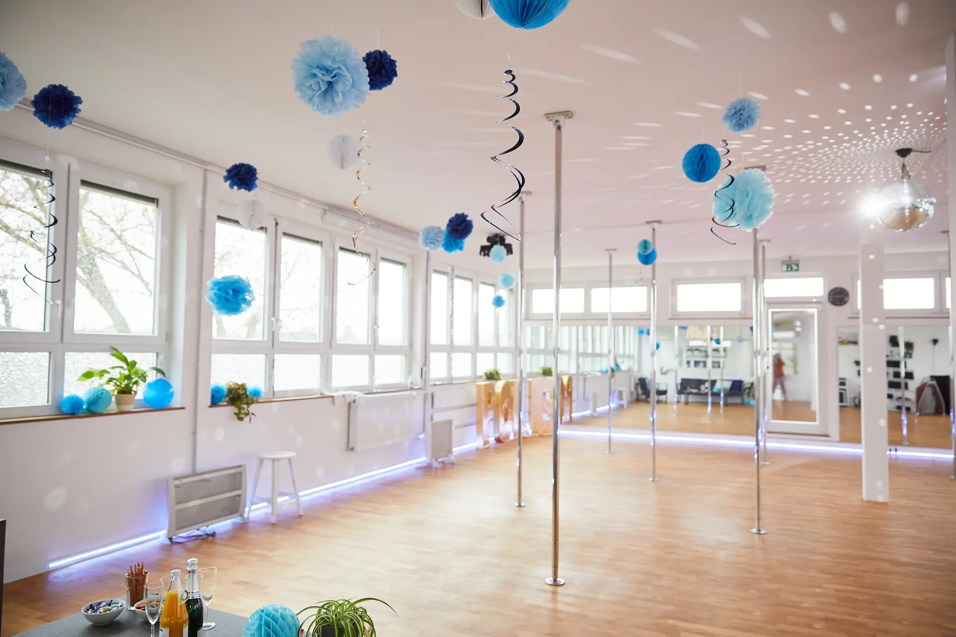 Studio mit blauer Pompon-Dekoration und Pole-Stangen